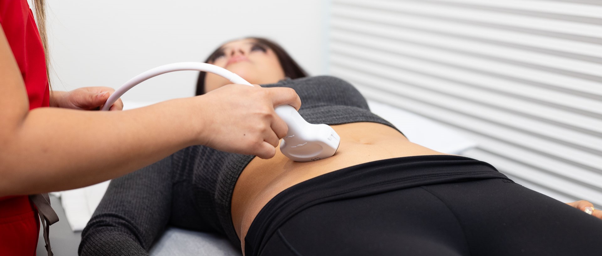 Open MRI of San Antonio patient receiving an abdominal ultrasound with a handheld ultrasound probe.