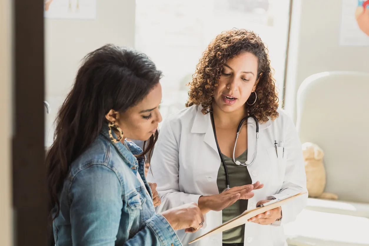 A female doctor discusses a diagnosis with the patient. They are reviewing the patient's test results.