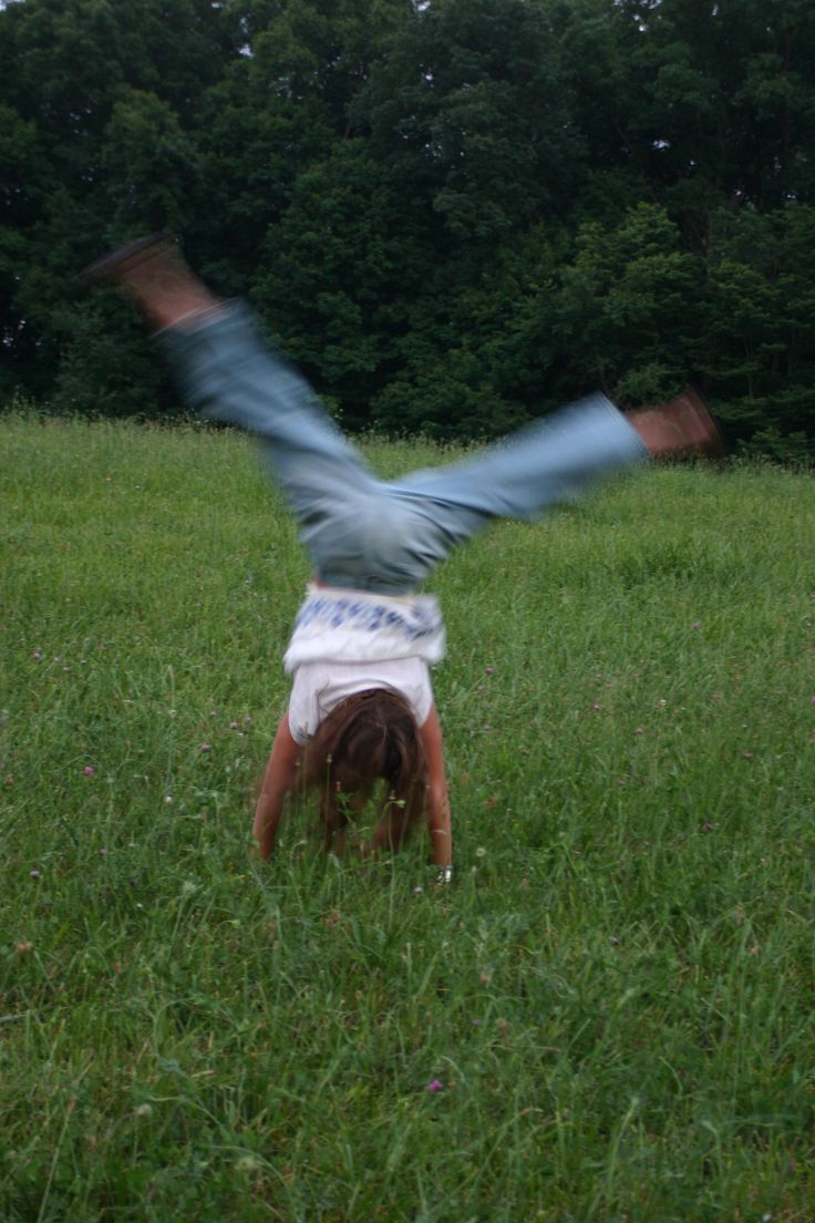 girl doing cartwheel in a field