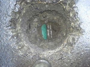 Close-up of a hole created by a vac showing the daylight hitting the utility lines.