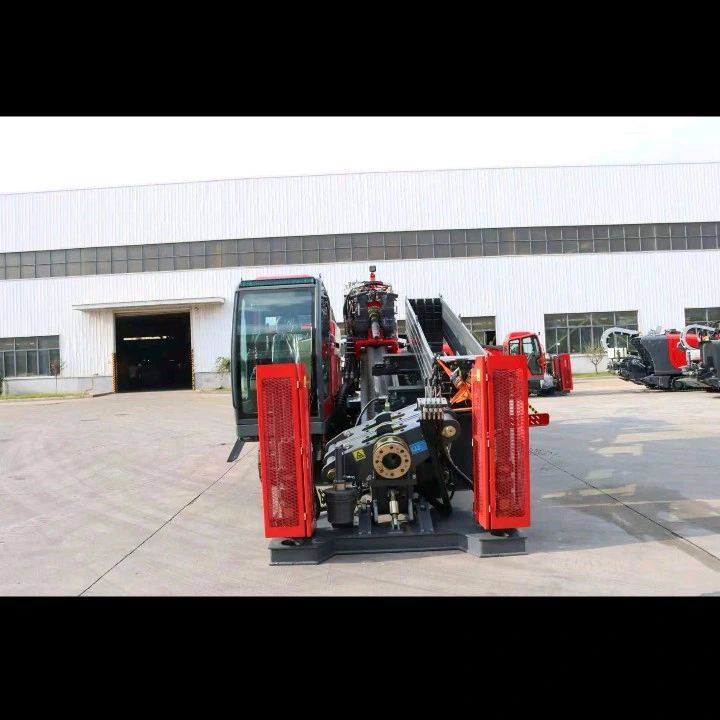 Front view of a G100 red and black industrial drilling machine outside a warehouse.