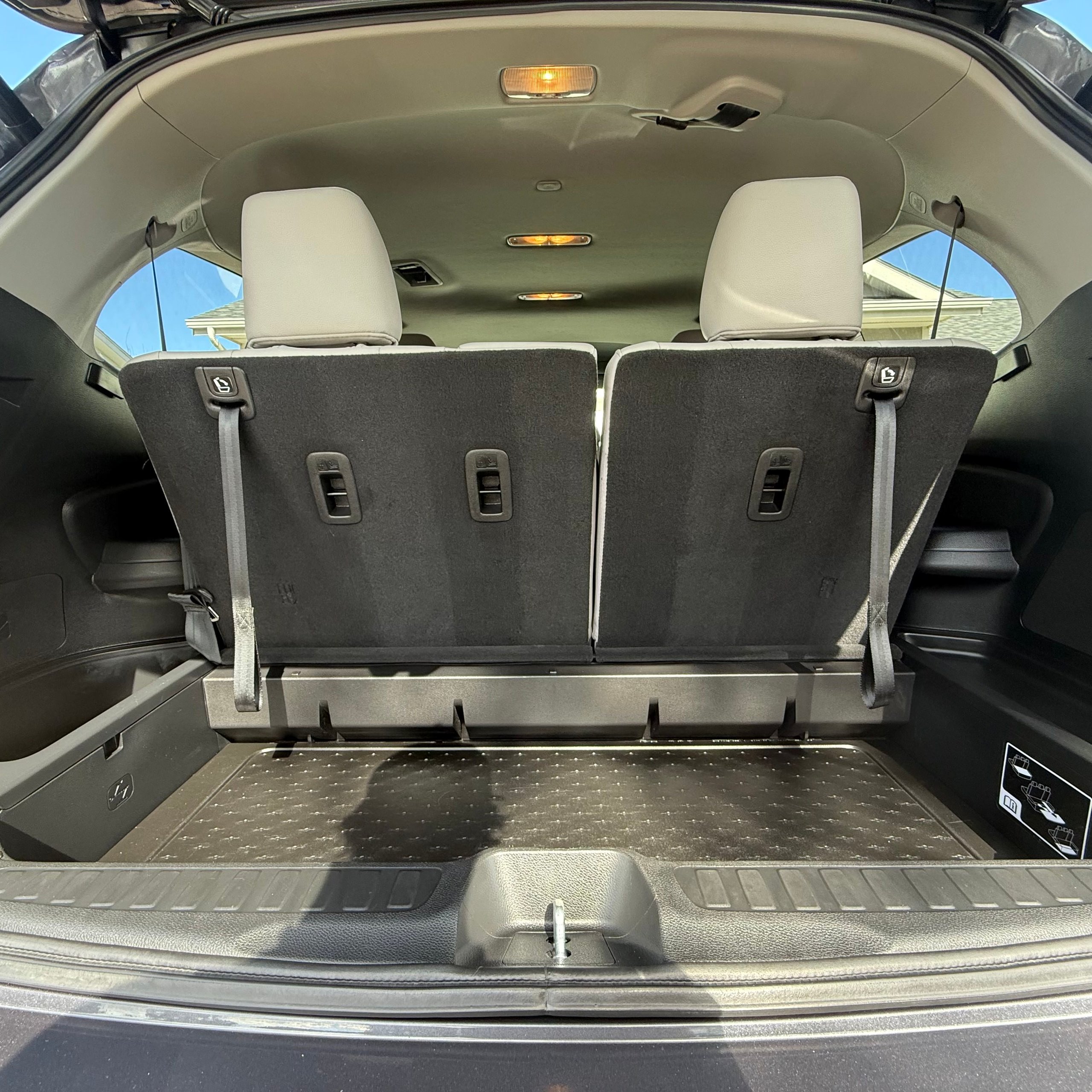 Open trunk view showing rear seats upright with black seat backs and beige headrests, and a spacious cargo area.