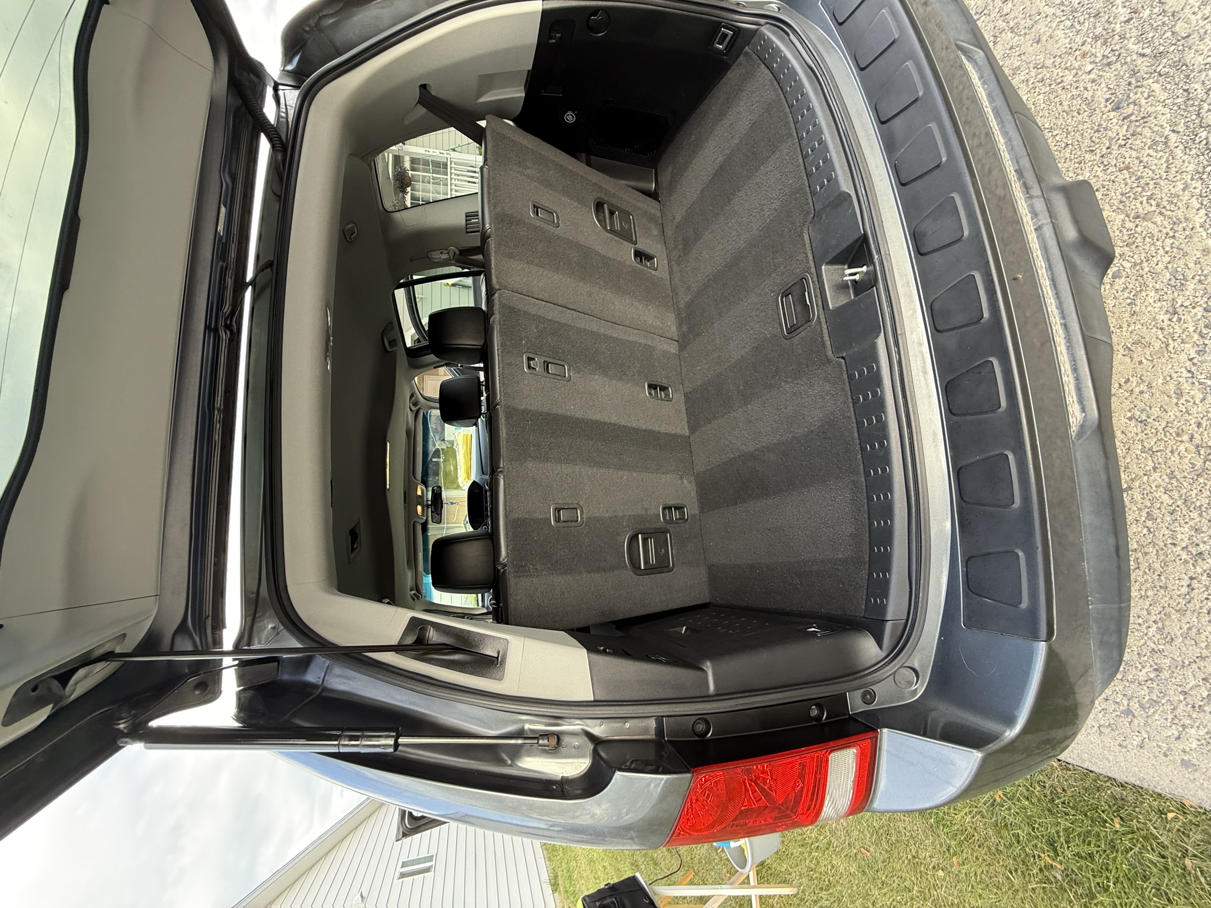 Interior view of a Volkswagen car showing a leather steering wheel, dashboard, black leather seats, and an American flag visible outside through the window.
