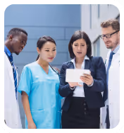 Group of diverse medical professionals looking at a tablet with serious expressions.