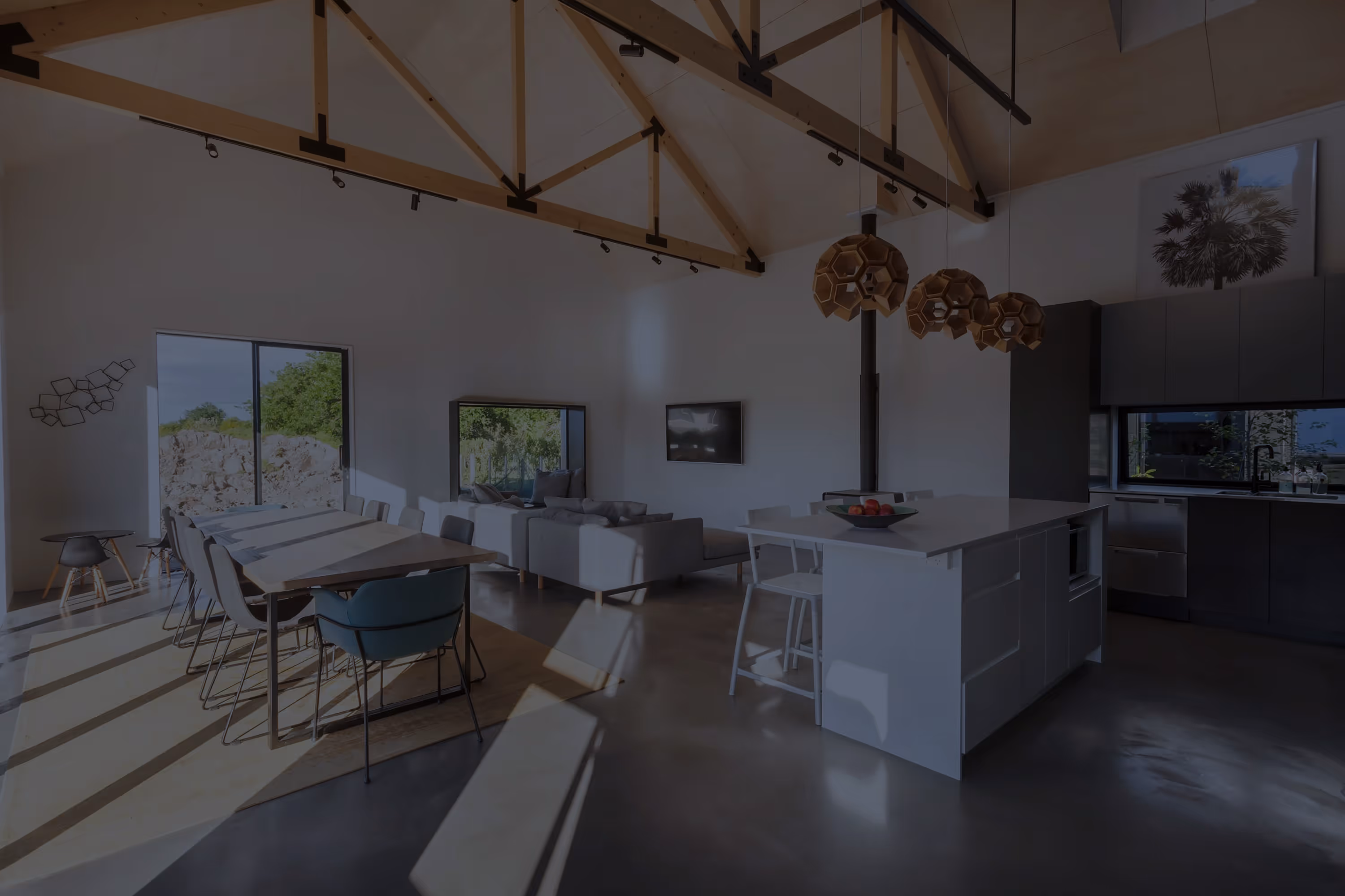 Saunders Residence open-plan living and dining area with grey sofas, dining table, and kitchen island.