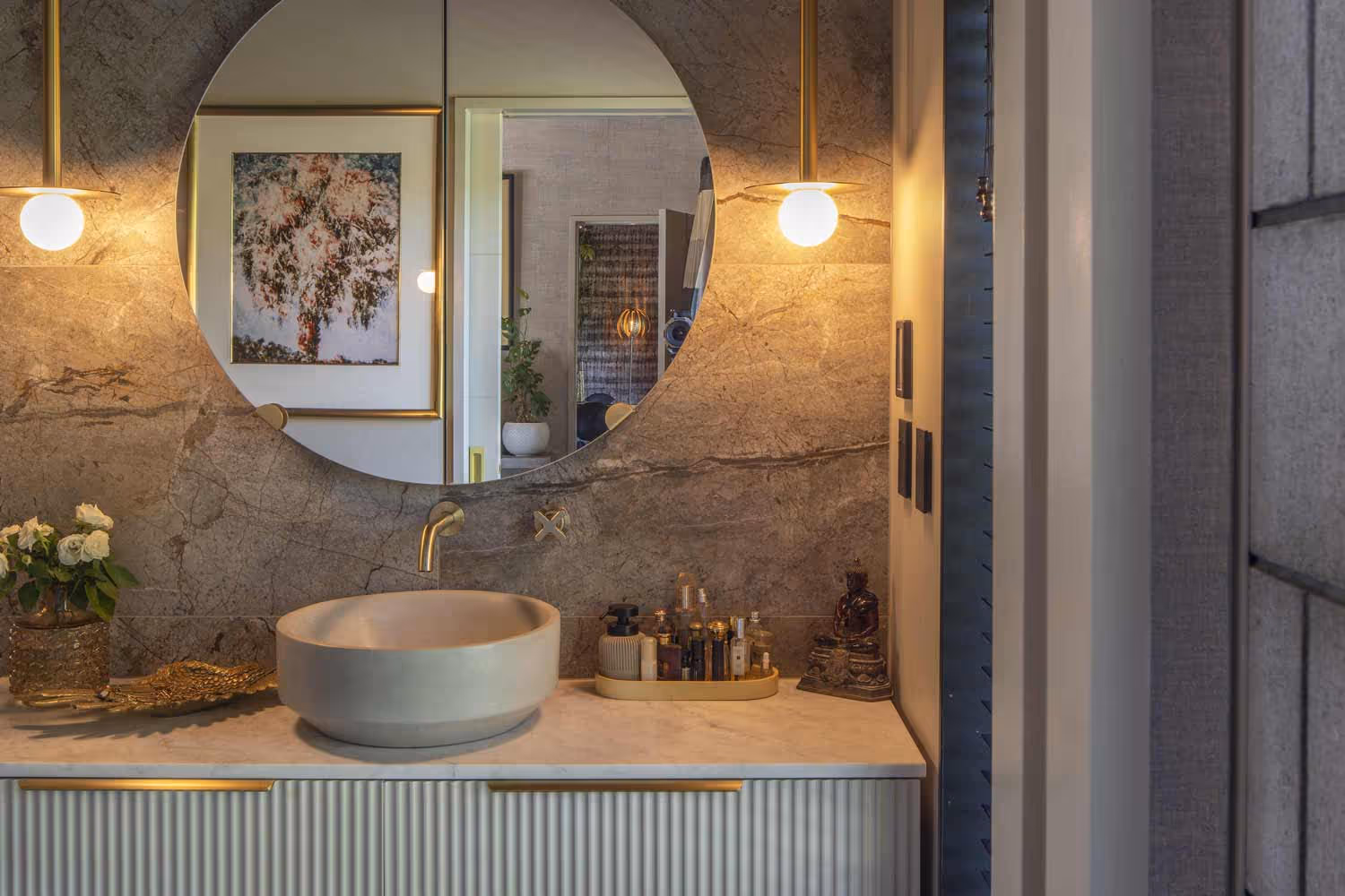 Bathroom vanity at the Smith House in Greytown with round sink, round mirror, and brass fixtures.