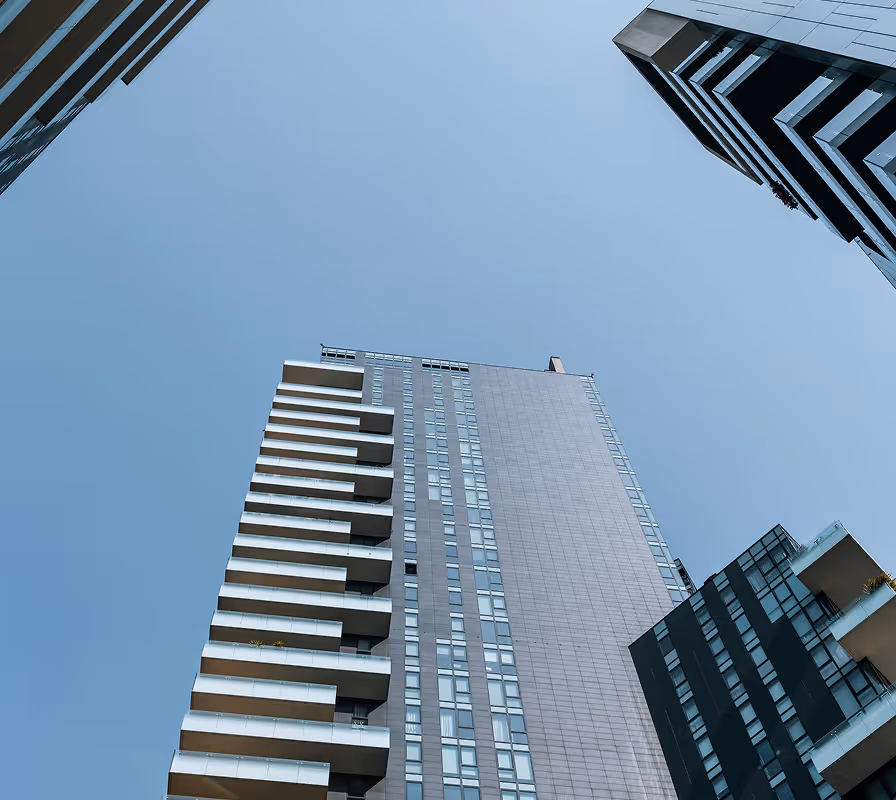 Modern high-rise apartment buildings shot from below against clear blue sky