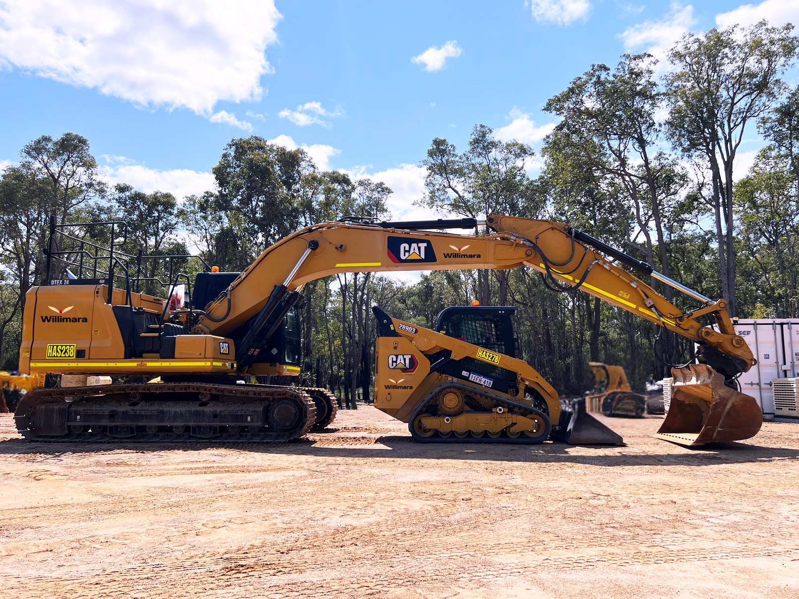 Large CAT excavator and smaller tracked loader with Willimara branding on dirt ground.