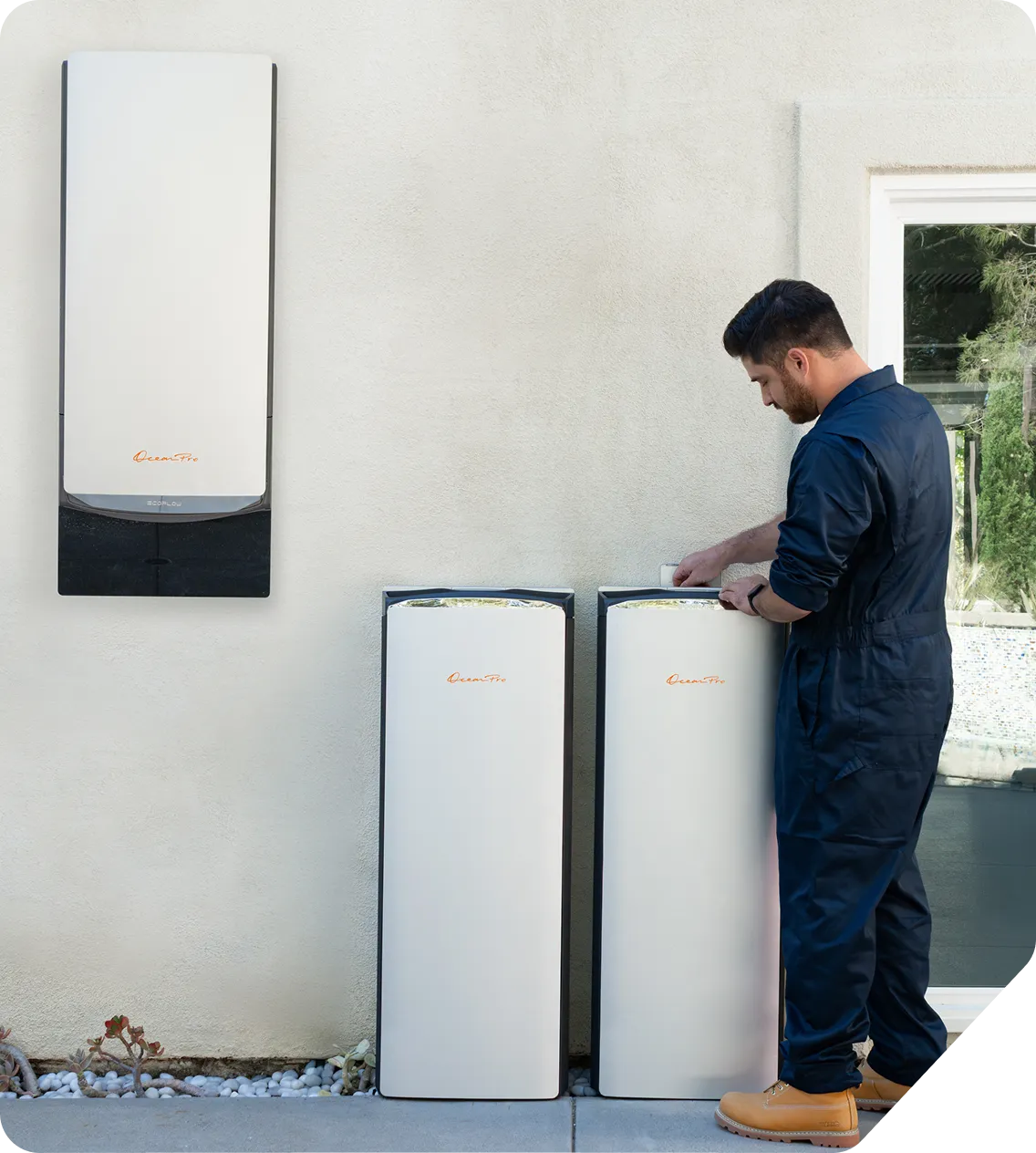 Night view of home exterior with a woman cleaning a window inside and a set of modern battery energy storage units connected outside.