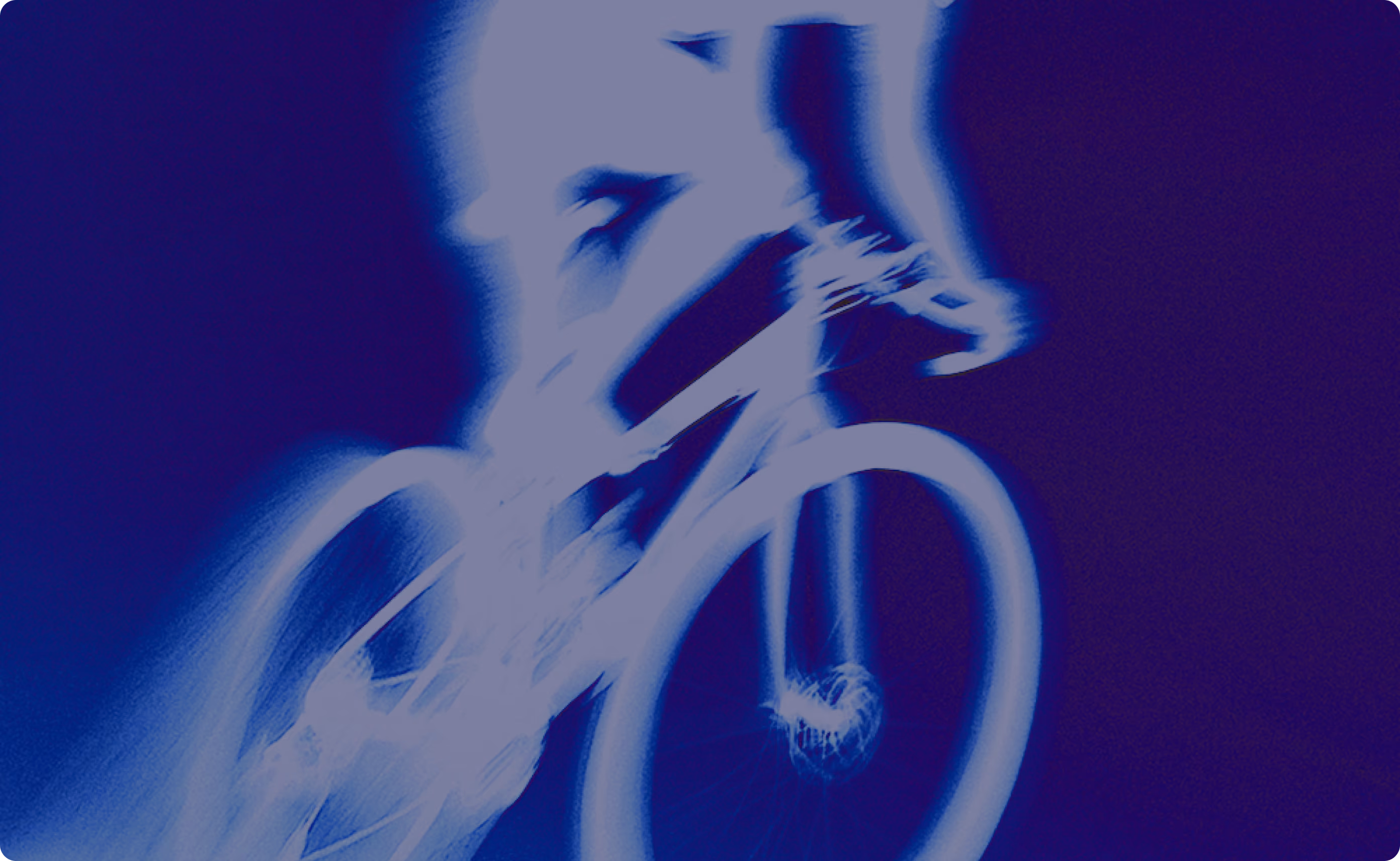 Blurred image of a cyclist on a bicycle in motion with a dark blue background.