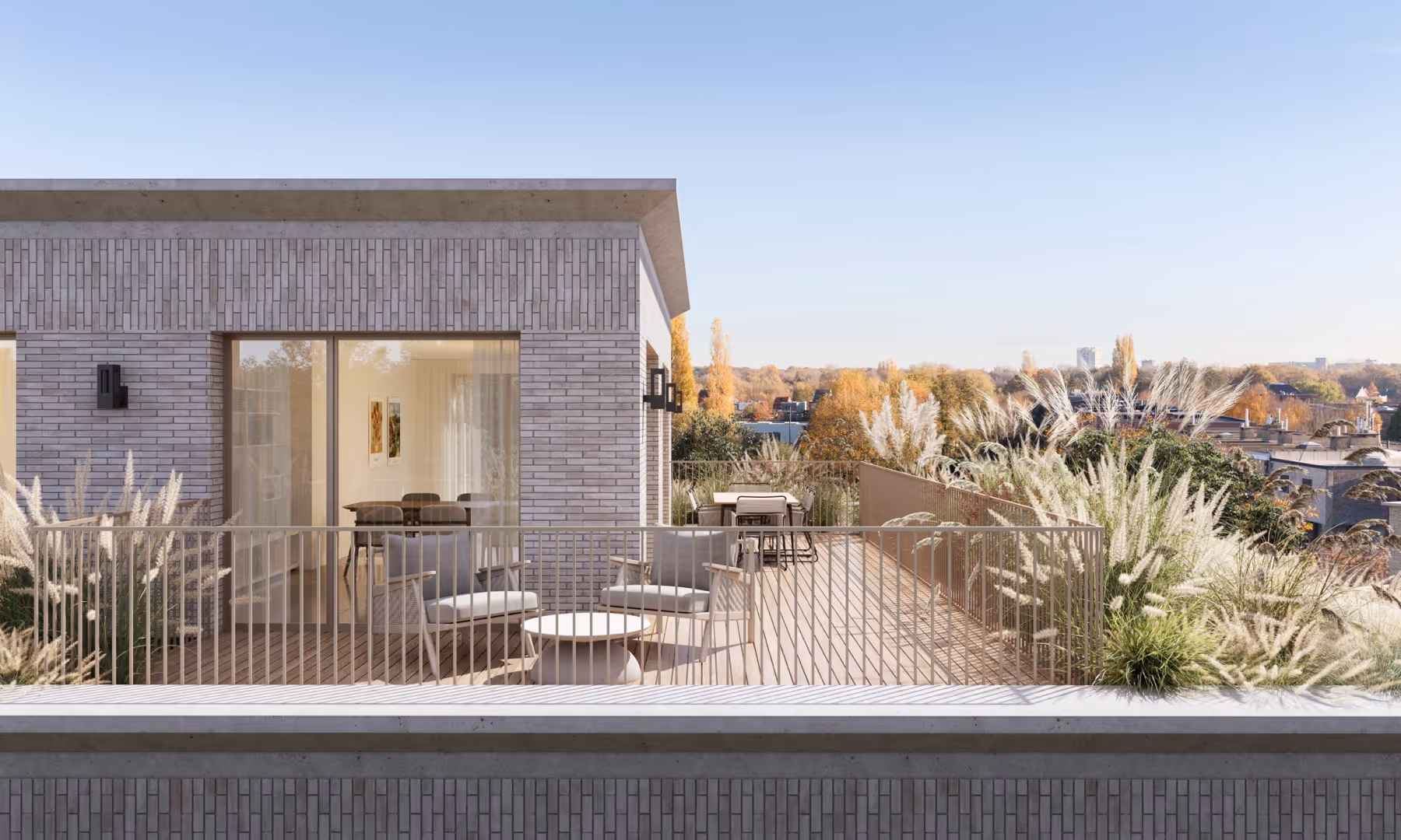 Modern dakterras van nieuwbouwproject Planeta in Wilrijk met lichtgrijze bakstenen muren, buitenzithoek, tafel, pampasgras en strakblauwe hemel.