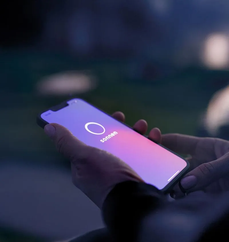 Hand hält Smartphone mit sonnen App.