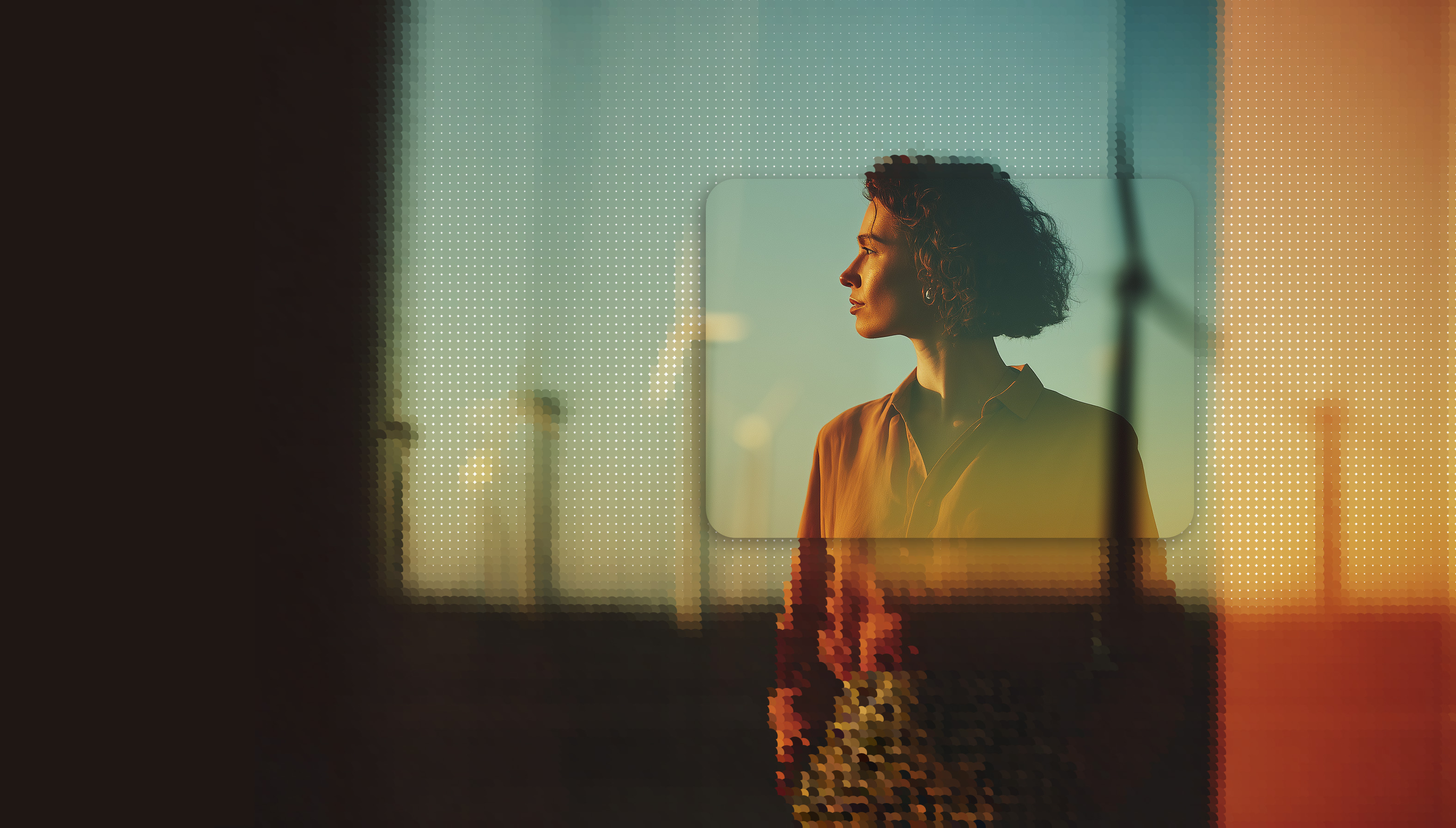 Profile of a woman with curly hair looking to the right against a blurred background with wind turbines at sunset.