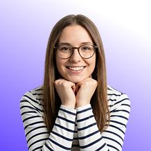 Smiling young woman with glasses resting her chin on her hands against a purple gradient background.