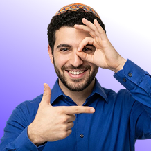 Smiling man in blue shirt wearing a kippah making a frame with his fingers.