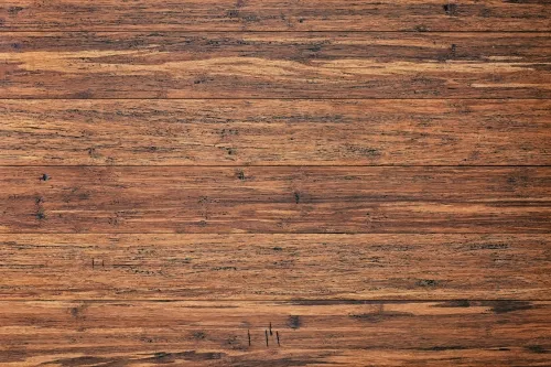 Smooth, reddish-brown wooden surface with natural grain and small dark knots.
