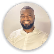 Portrait d'un homme souriant avec une chemise blanche sur fond clair.