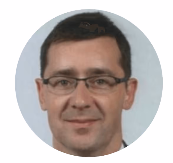 Portrait d'un homme aux cheveux bruns et lunettes souriant légèrement.