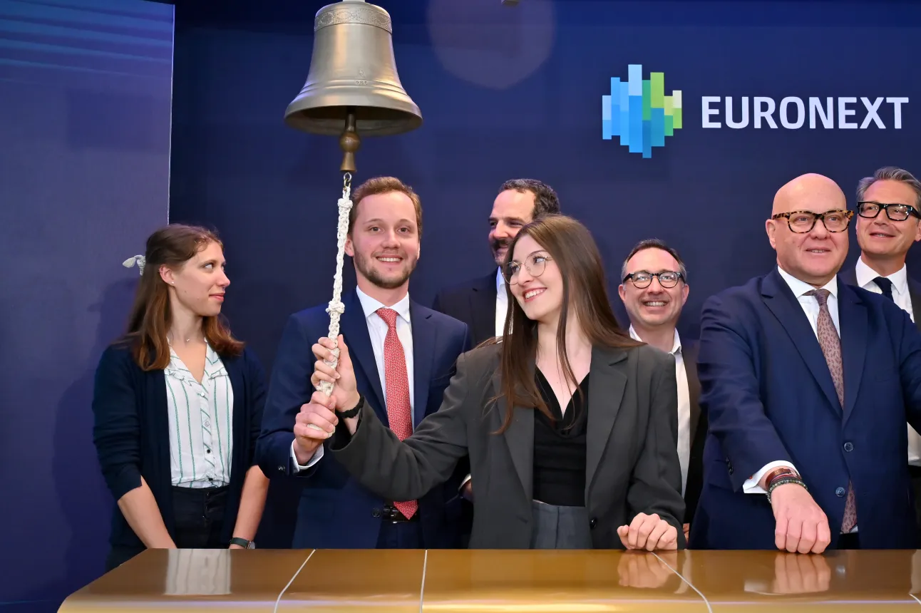 Un groupe de personnes en costume sonne une cloche devant le logo Euronext.
