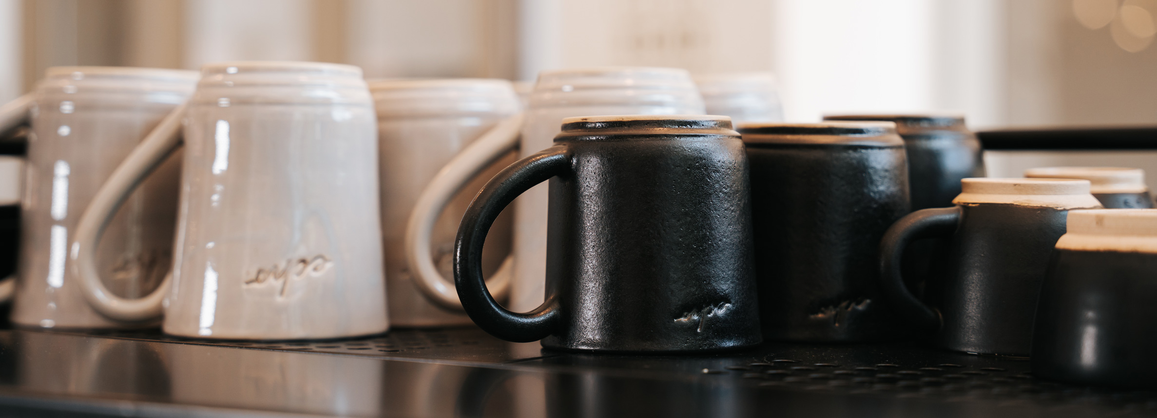 Our beautiful ceramic echo mugs in black and cream colours.