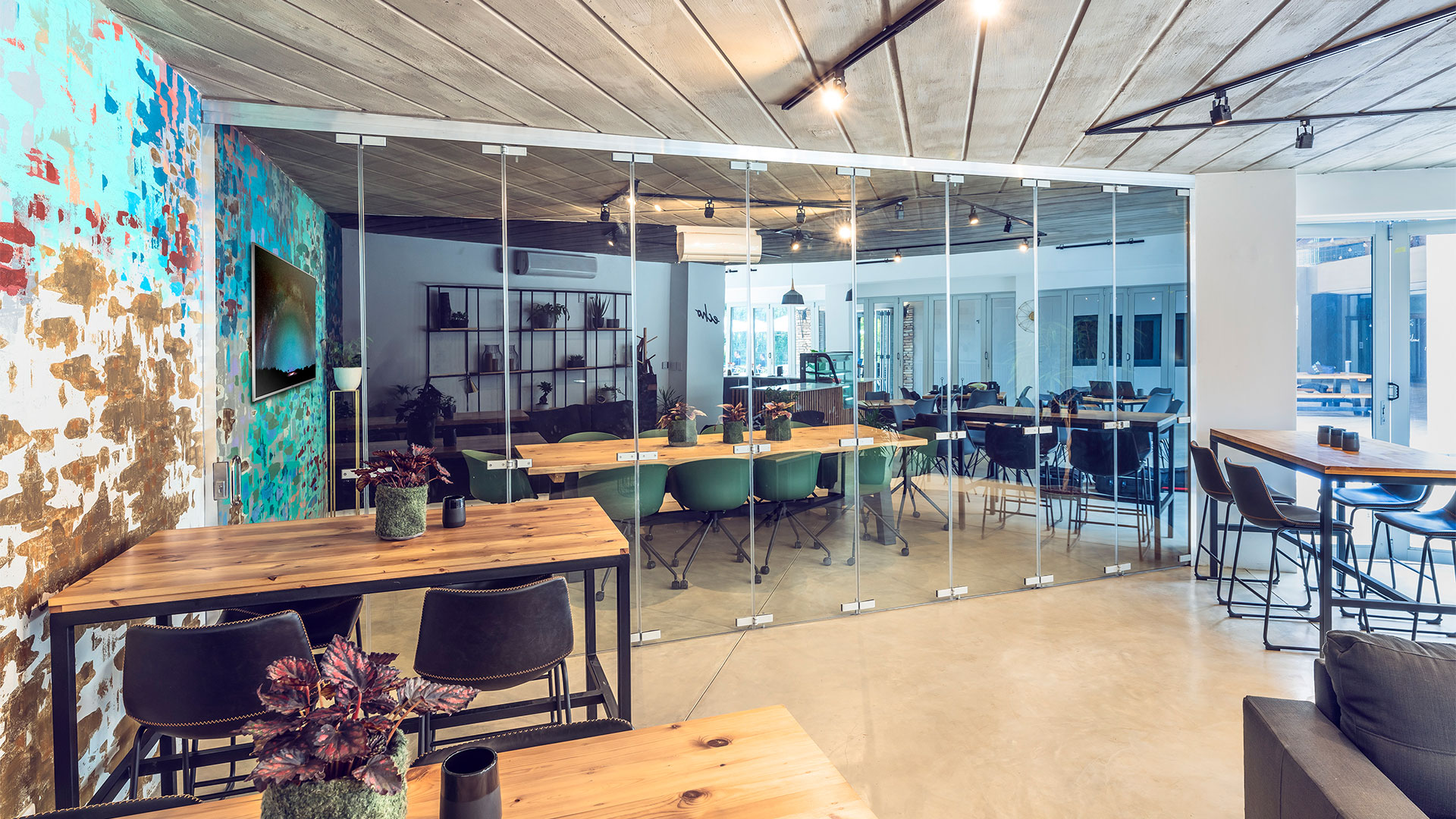 Echo boardroom viewed from outside the folding glass wall standing next to the painted wall.