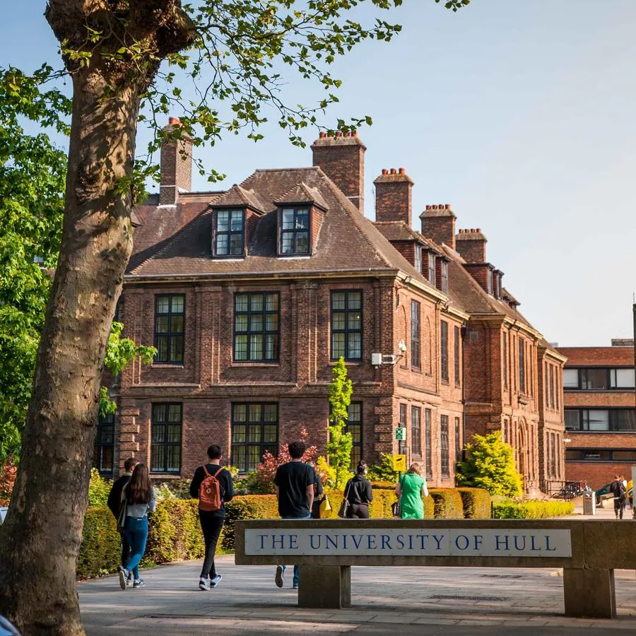 Students walking past a University of Hull campus sign