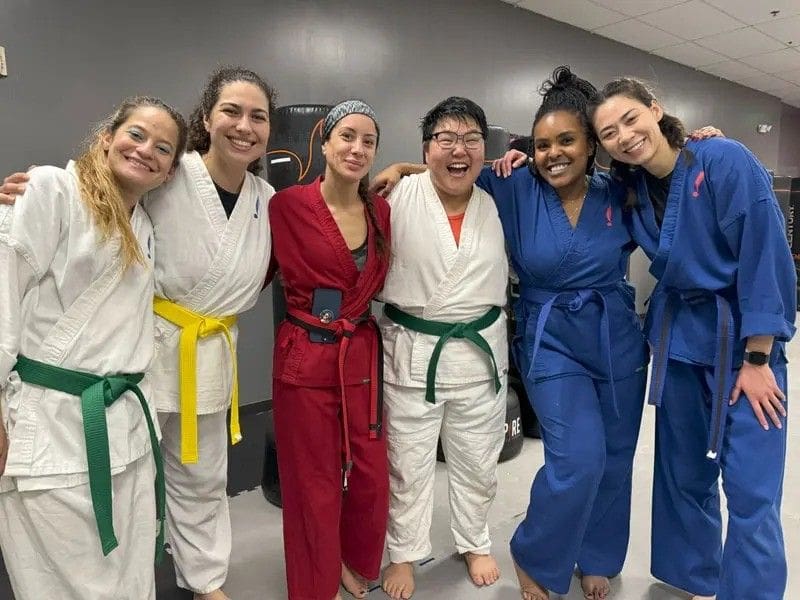 Women celebrating progress after finishing an empowering self defense training class.