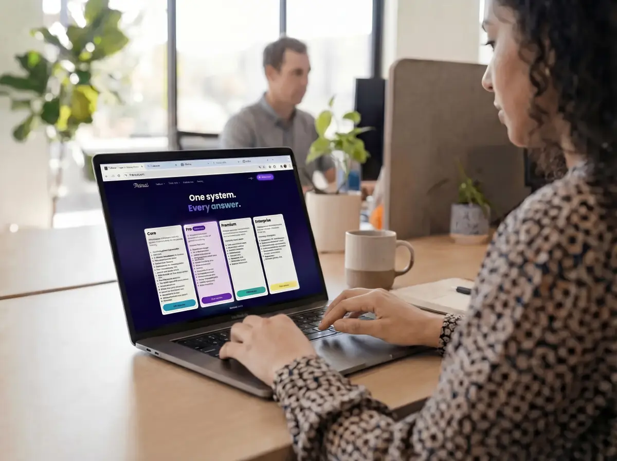 Person working on a laptop displaying a software pricing plans page with Core, Pro, Premium, and Enterprise options.