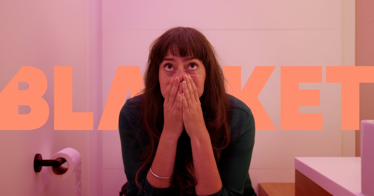 Woman sitting in a bathroom with hands covering her mouth and looking upwards, with large semi-transparent text 'BLANKET' in the background.