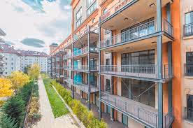 Building with balconies on the right and a park on the left