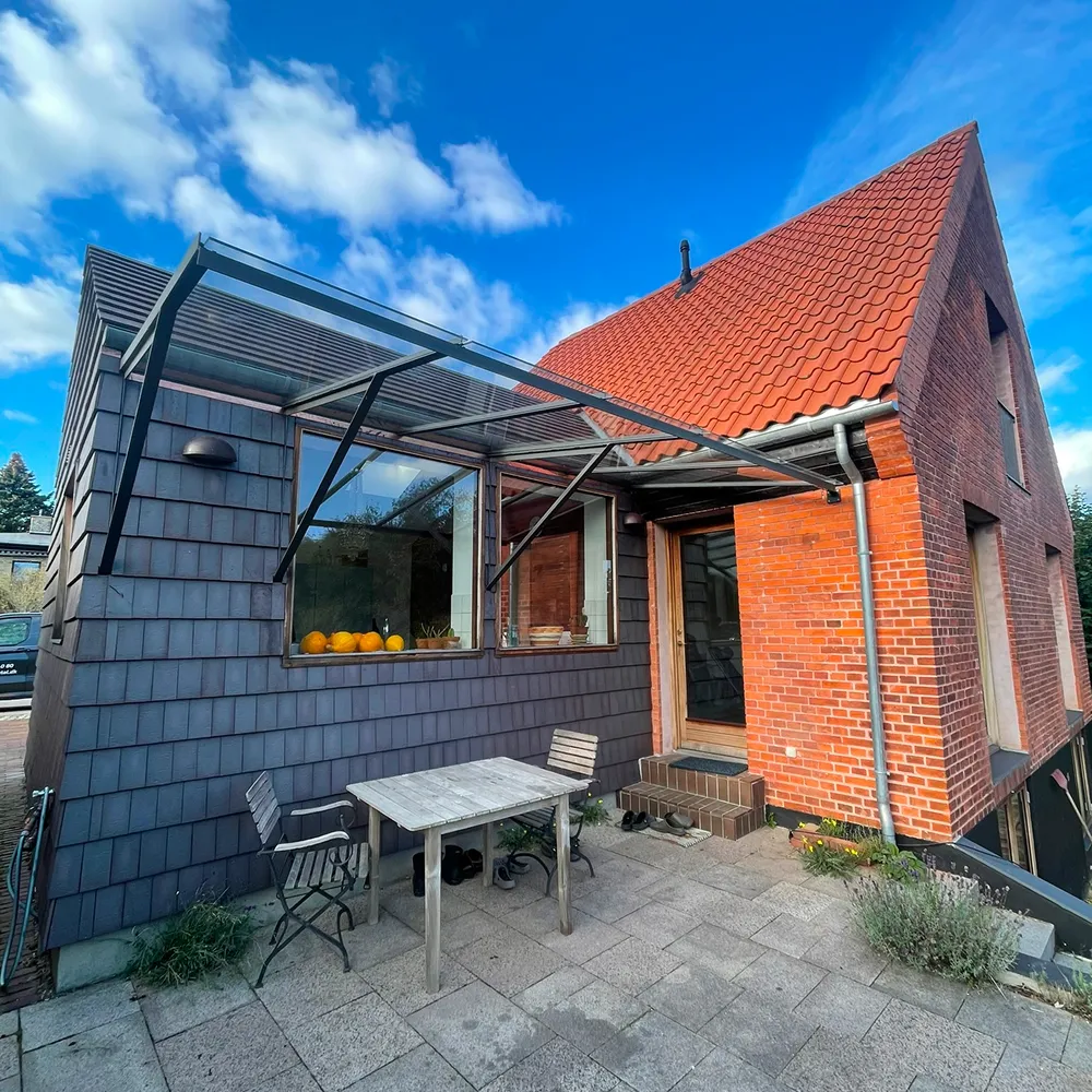 Specialfremstillet udhæng i stål og glas over terrasse, leveret og monteret af din smed i København.