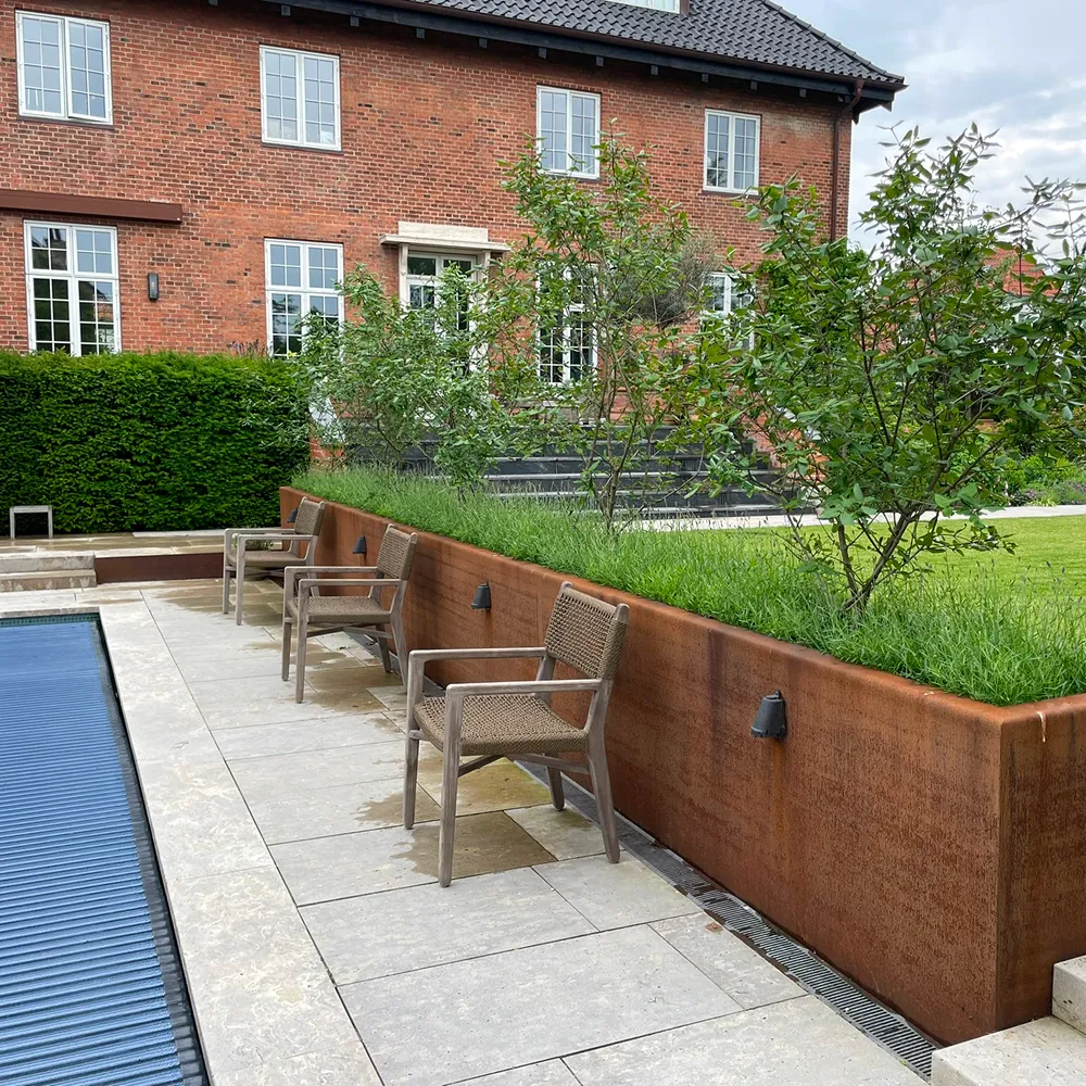 Moderne haveanlæg med store plantekasser i Corten stål, leveret og monteret af smed.