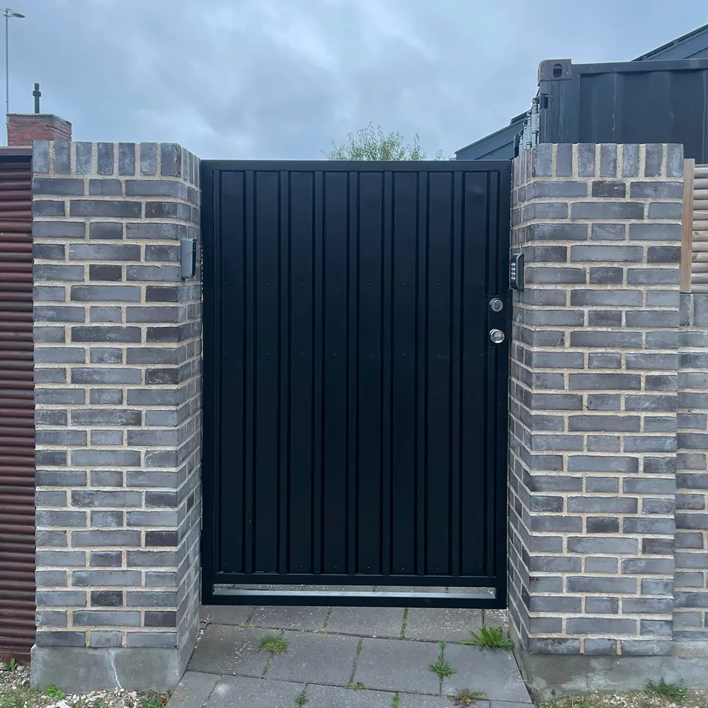 Sort metalport i minimalistisk design monteret mellem murede søjler af CMP Metal.