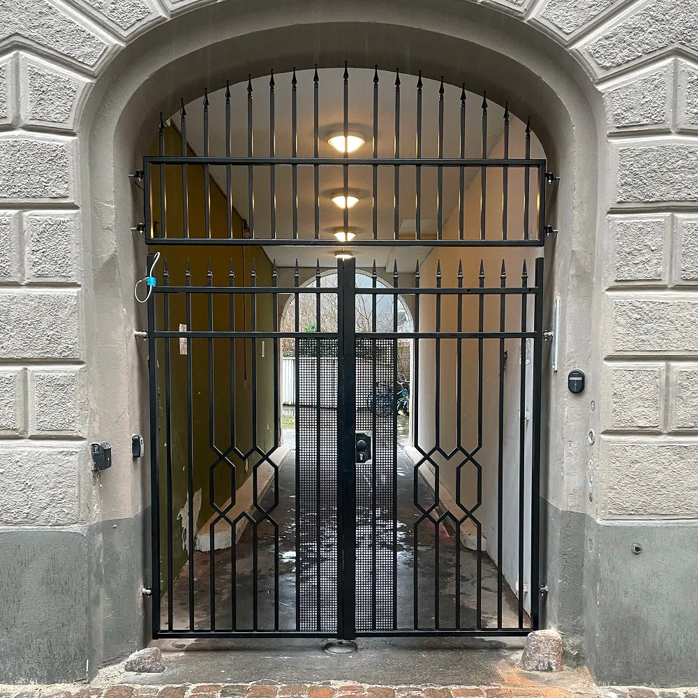 Sikkerhedsgitter i klassisk design monteret i muret buegang af faglært smed i København.