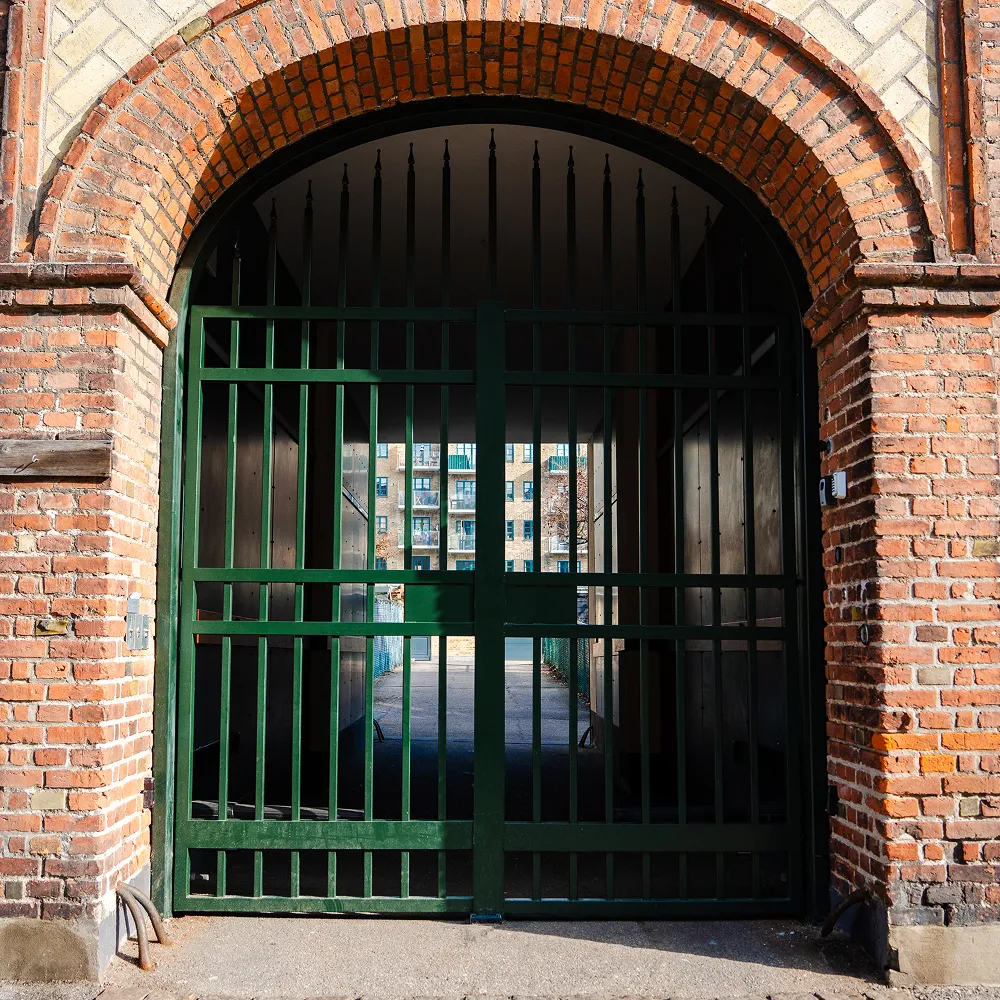 Grønmalet, specialfremstillet smedejernsport monteret i muret portåbning i Valby.