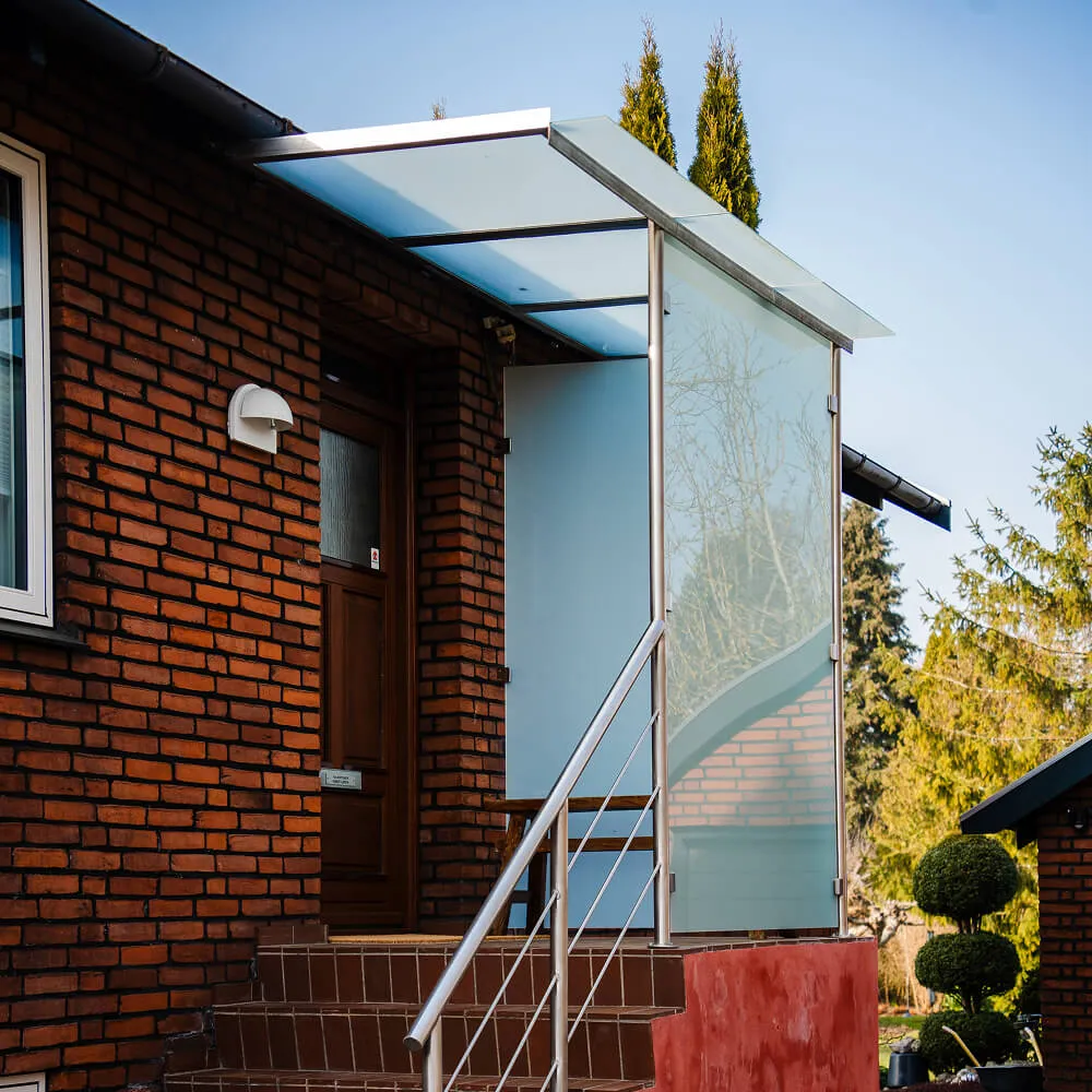 Elegant indgangsparti med glastag og stålgelænder, monteret af smed i Rødovre