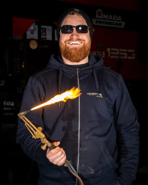 Charlie som ejer CMP Metal viser skærebrænderen på værkstedet i København.