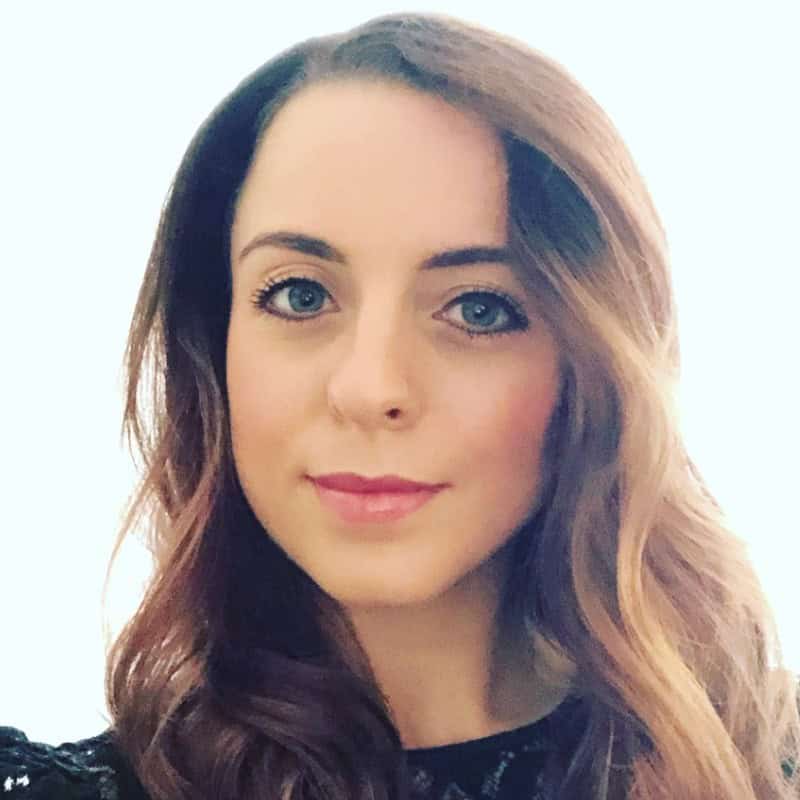 Portrait of a woman with long brown hair and blue eyes against light background