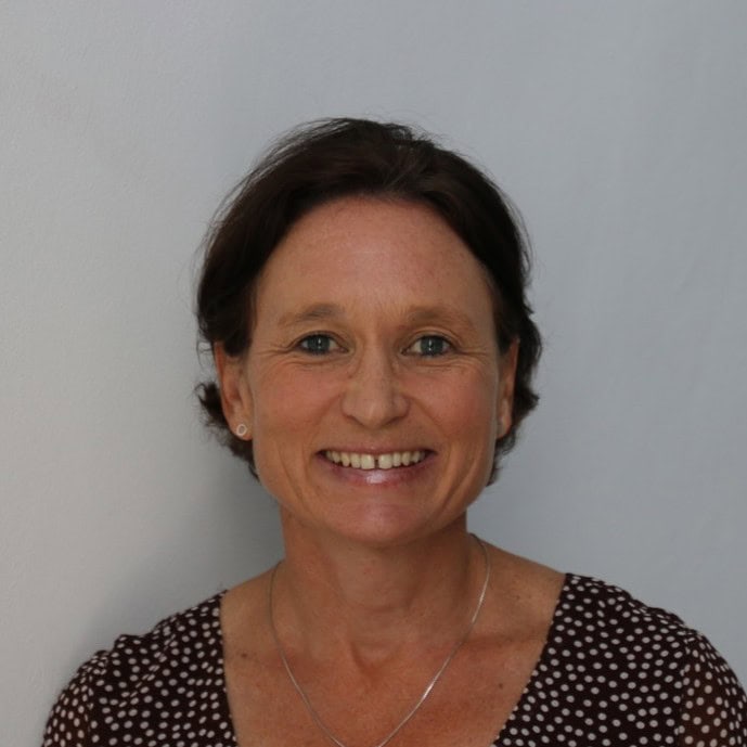 Portrait of a smiling woman with dark hair wearing a polka dot shirt
