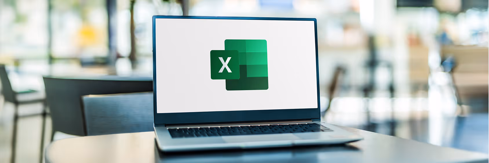 Open laptop showing the green Microsoft Excel logo on screen in a bright cafe