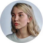 A woman with blonde hair is looking at the camera.