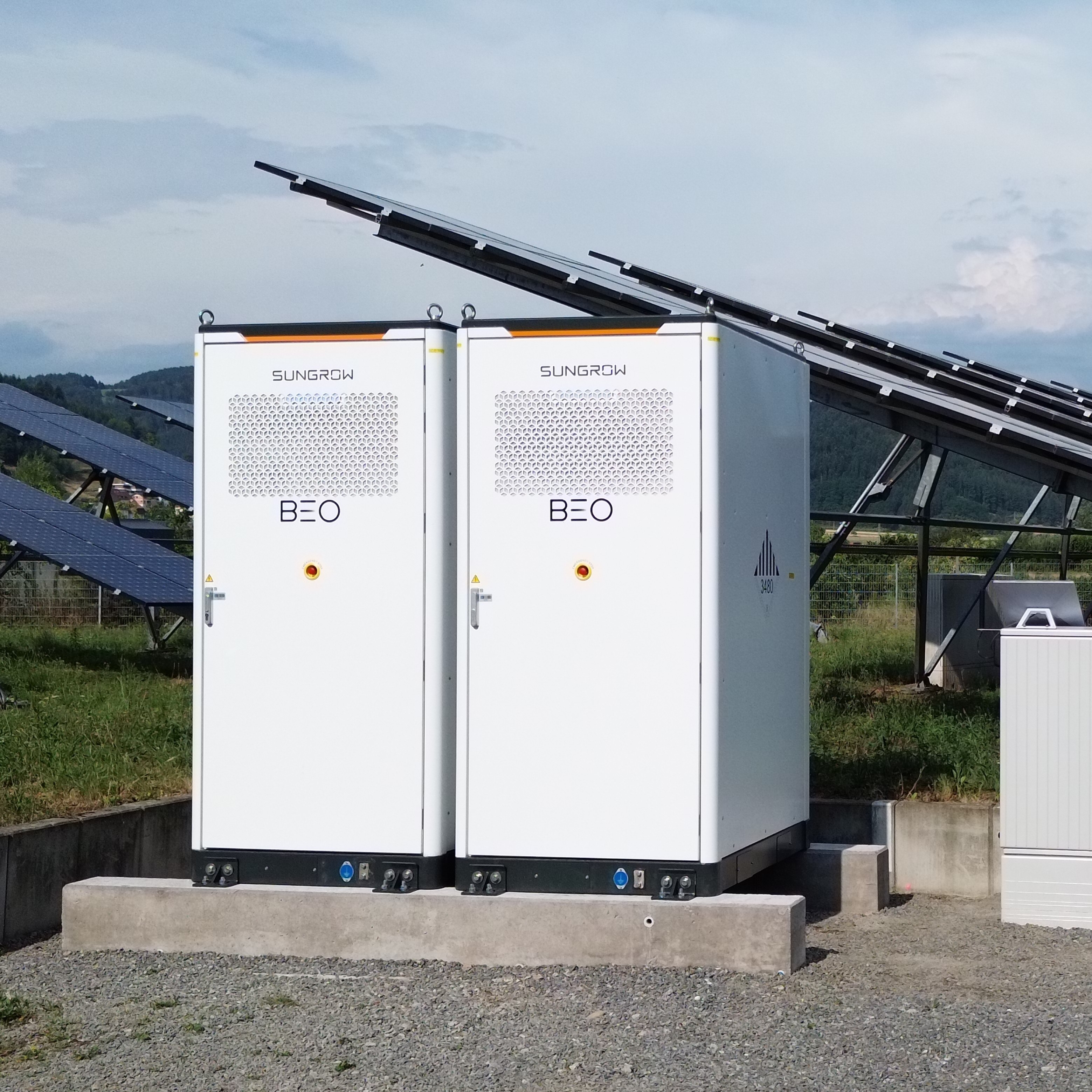Hochspannungsleitungen und Strommast vor bewölktem Himmel