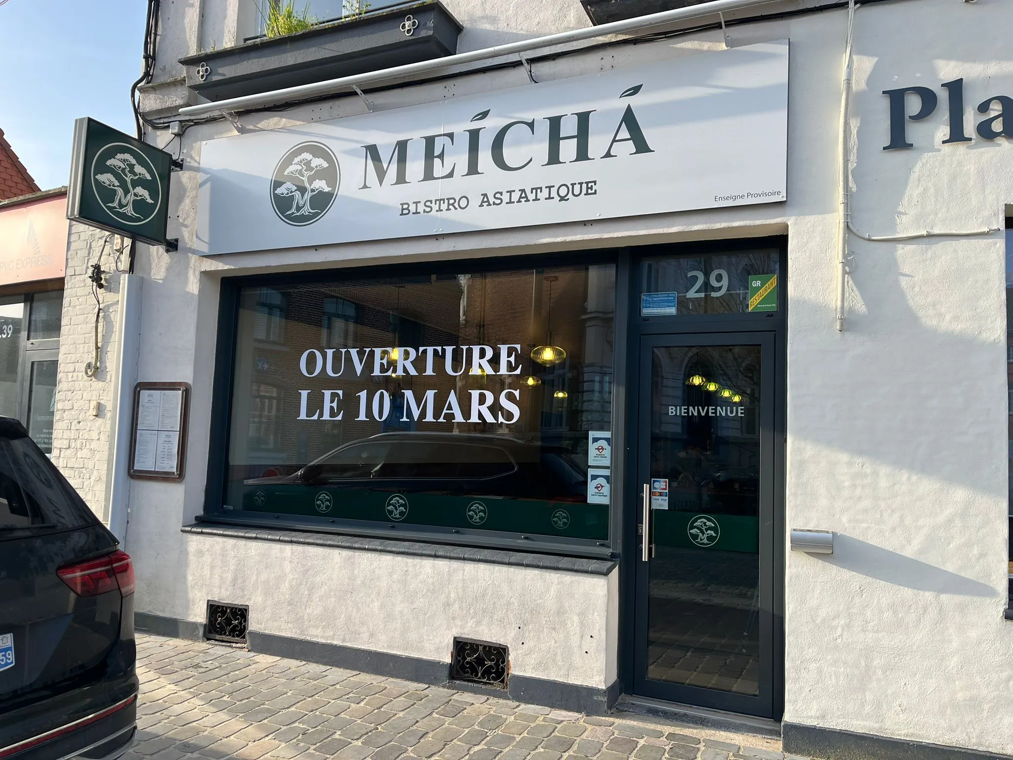 Façade du bistrot asiatique Meíchá avec annonce d'ouverture le 10 mars sur la vitrine.