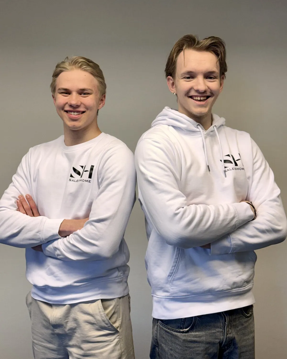 Kaksi Saleshomen myyjää toimistolla Saleshome-paidoissa.