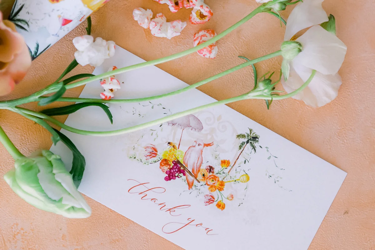 Floral thank you card with white flowers and popcorn on a textured peach background.