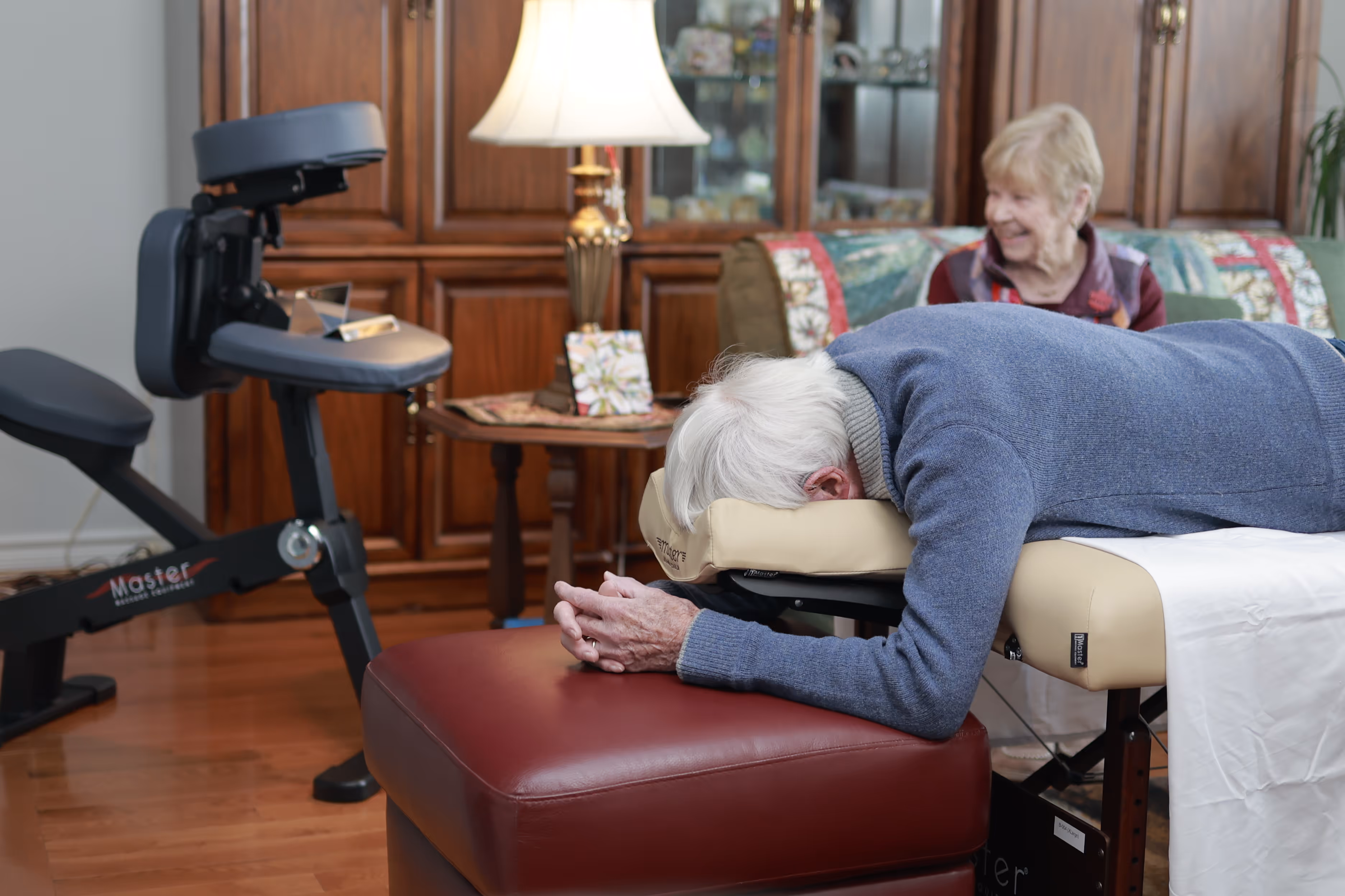A person face down comfortably on a face down bed next to their face down chair in the living room.
