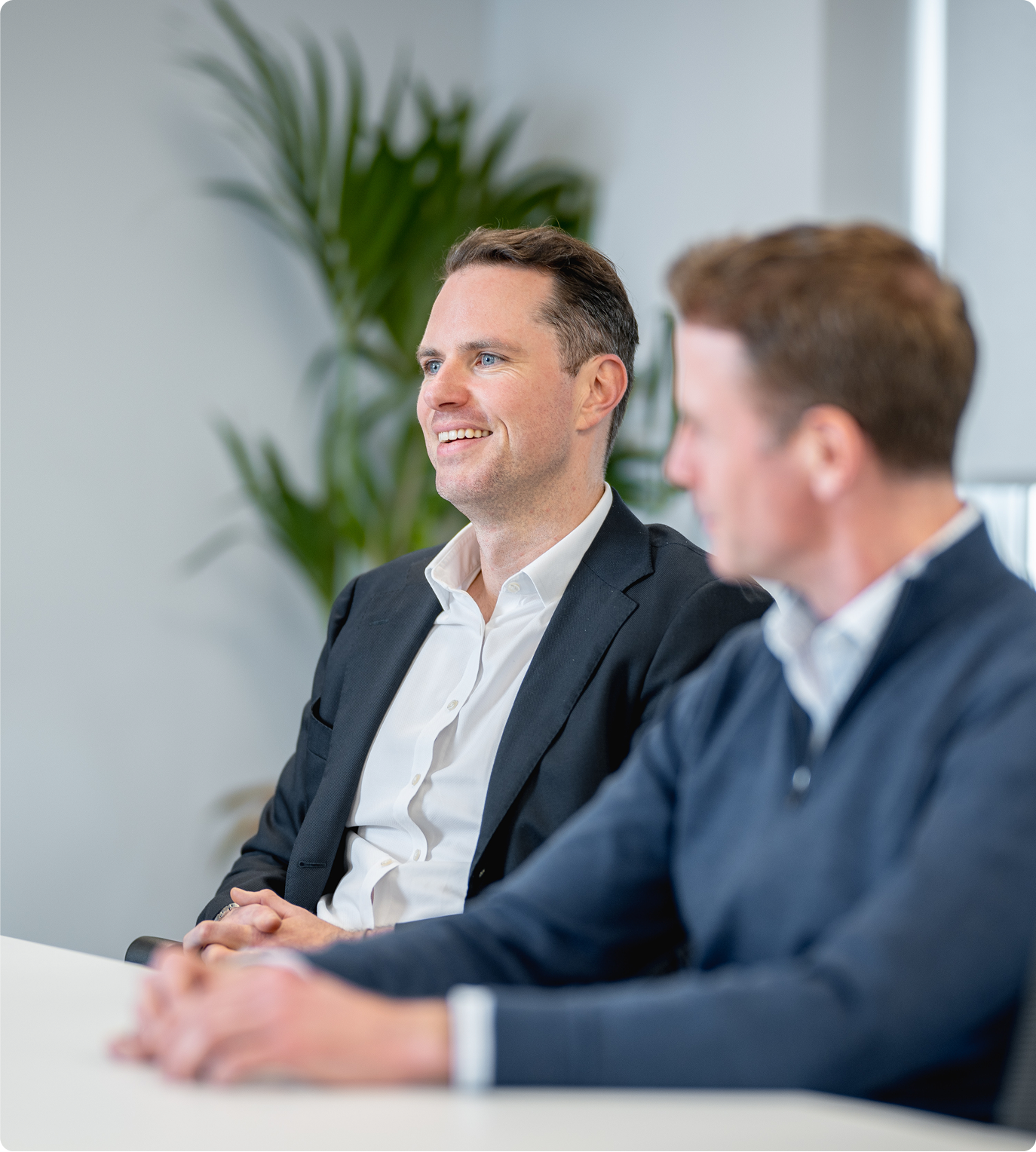 Two colleagues smiling in a meeting