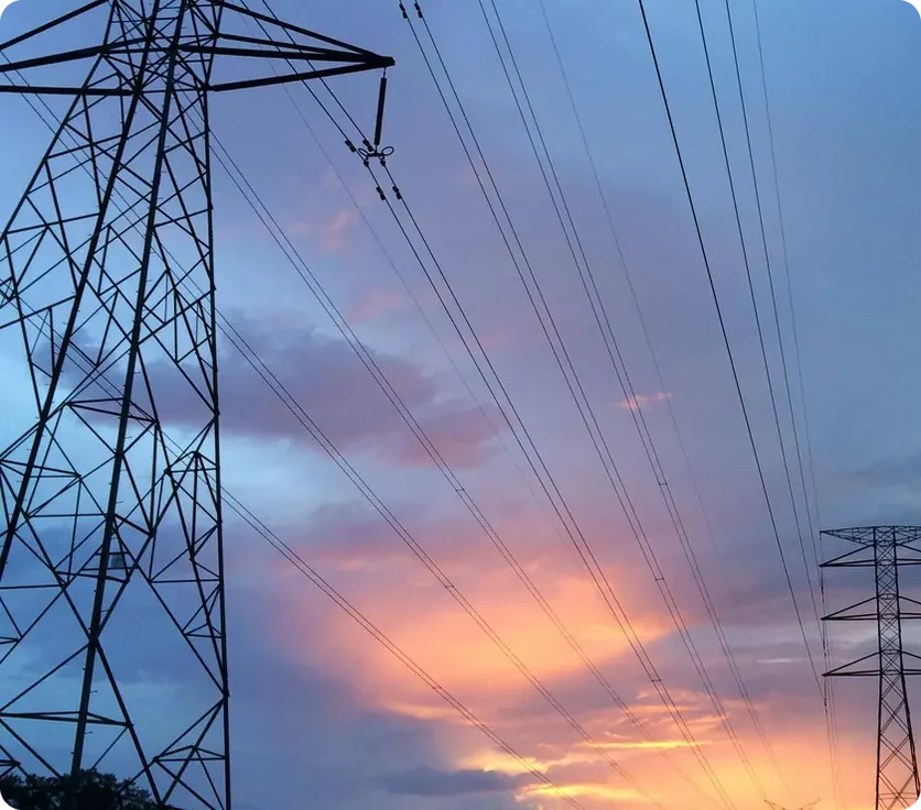 Electricity pylons against a sunset sky