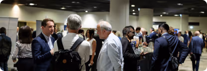 Groupe de personnes discutant lors d'un événement dans un grand espace intérieur.