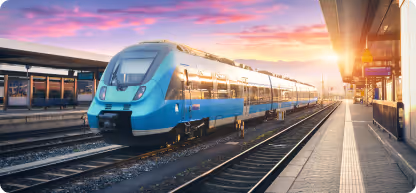 Train bleu moderne s'arrêtant à une gare sous un coucher de soleil vibrant.
